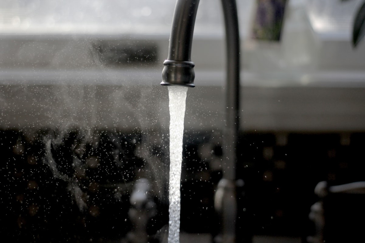 A kitchen tap running — the household water that every ratepayer is billed for.